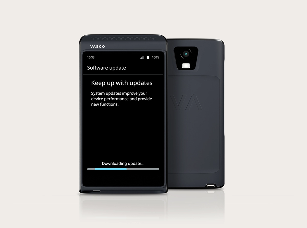 A studio shot of the Vasco Translator Q1 showcasing the software update process. Two devices are shown: one from the front and one from the back. The front device displays a 