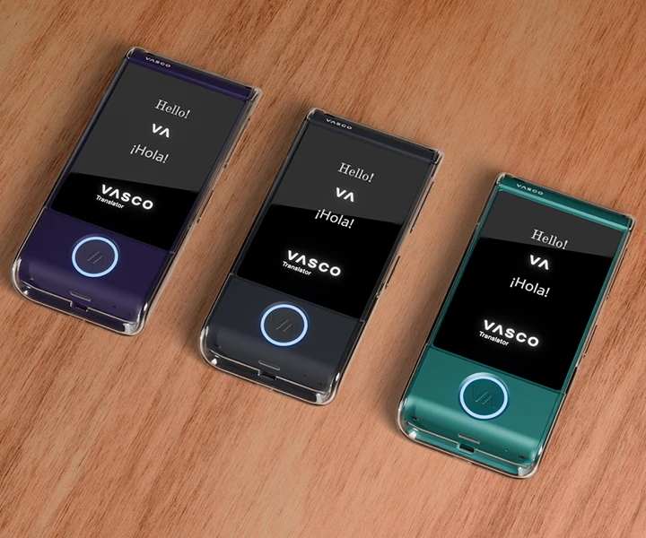 Three Vasco Translator M4 devices lying on a table in transparent silicone cases in three different colors, with screens turned on showing the Vasco logo and illuminated LED buttons.
