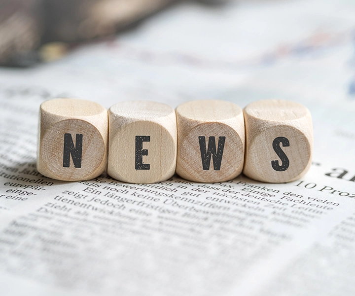 Cezary Pazura in ski outfit holding skis in one hand and a Vasco Translator Q1 in the other